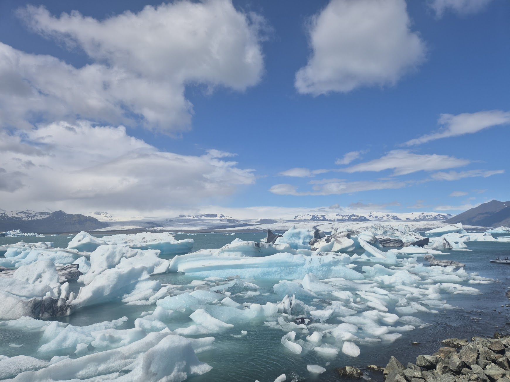 Blue icebergs floating in Jökulsárlón glacier lagoon with Vatnajökull in the distance